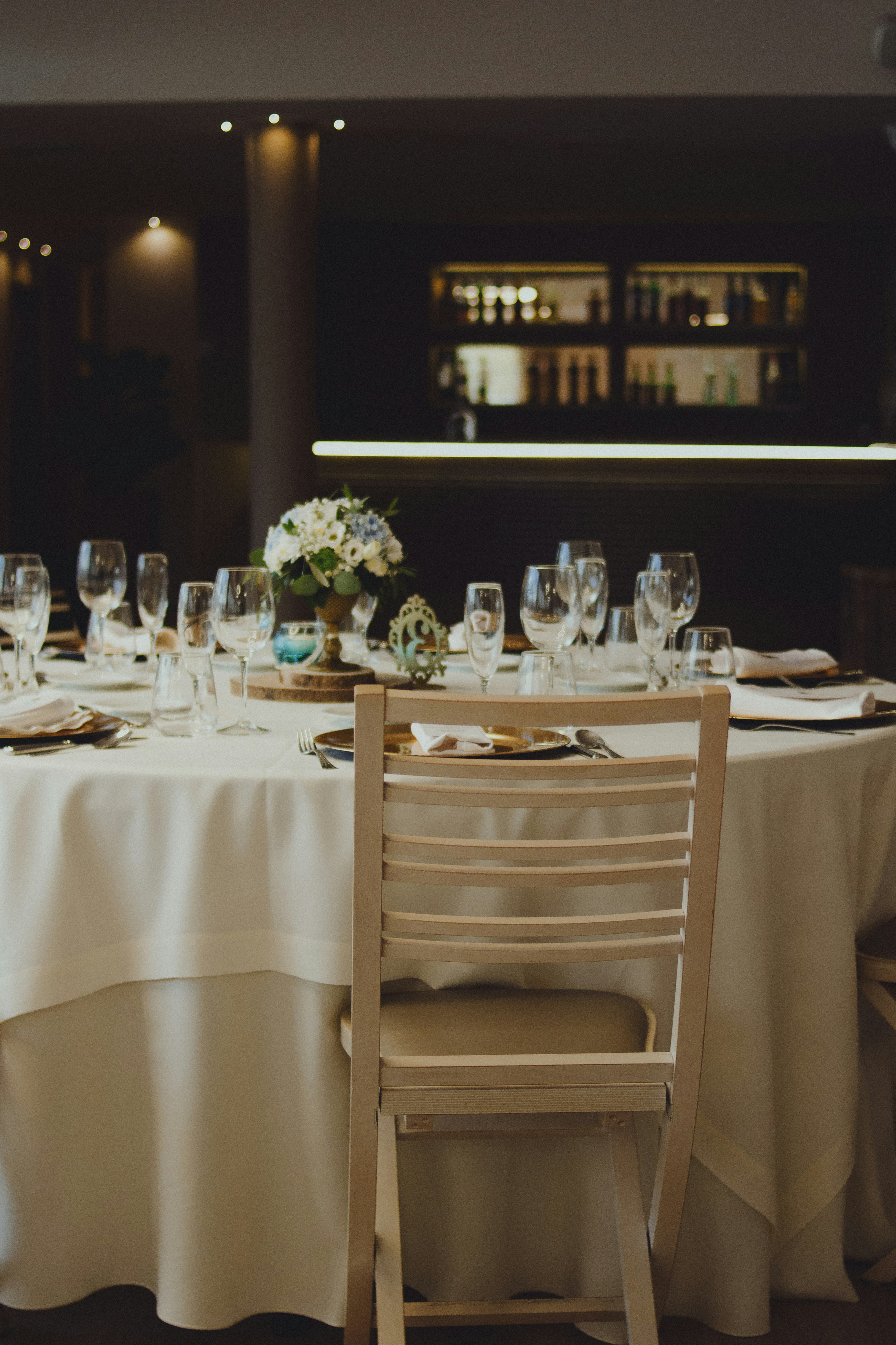 white wooden chair beside table with plates and glasses